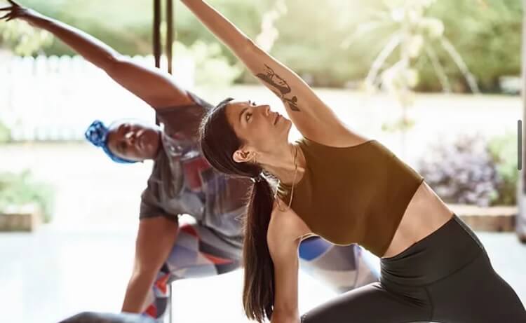 White and black woman practicing yoga