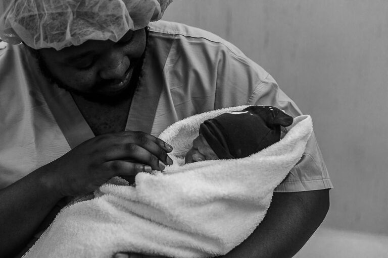 Black dad holding brand new baby